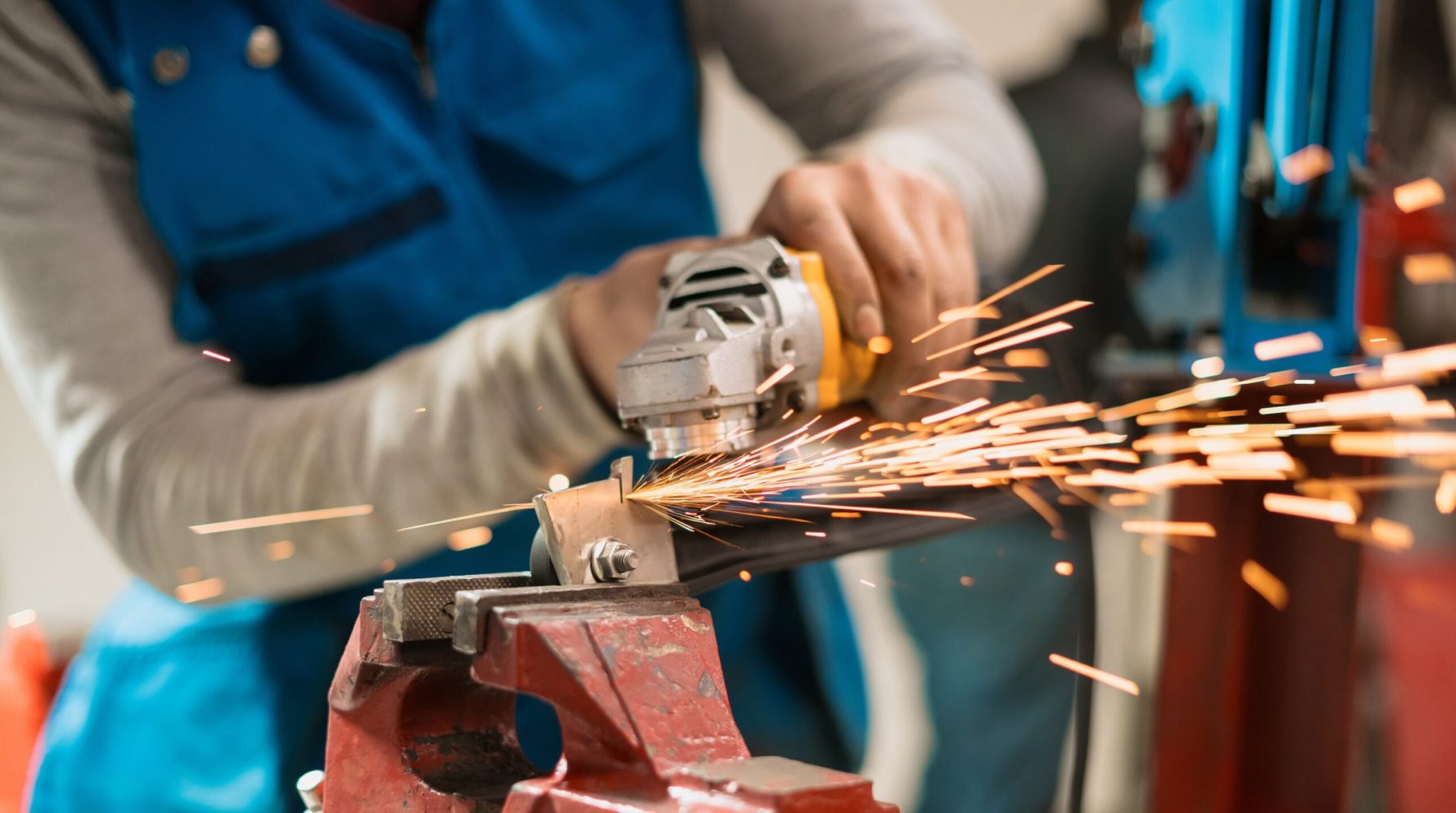 Technician worker cutting metal with many sharp sparks. Using equipments to cat iron